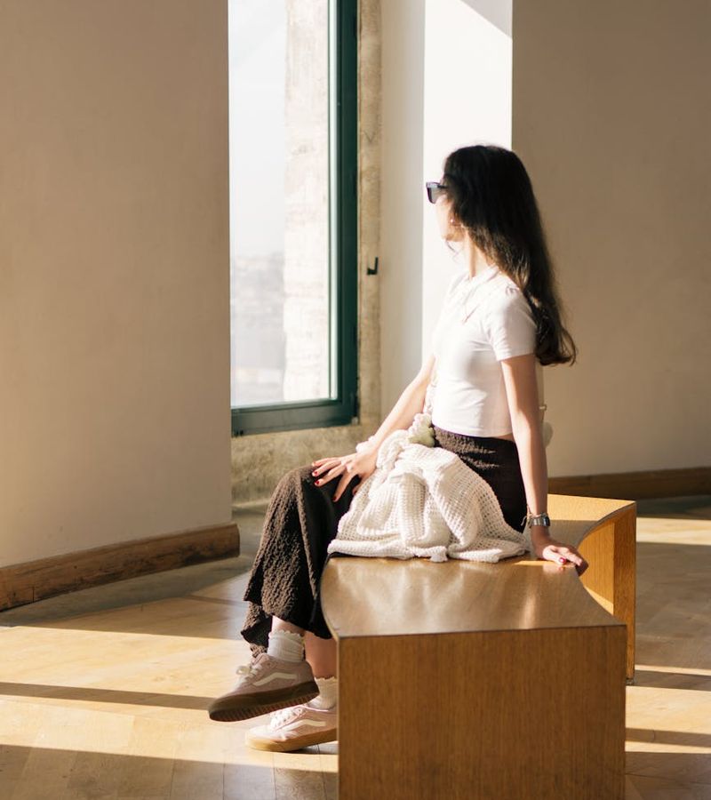Woman in a calm yoga pose in a softly lit room.